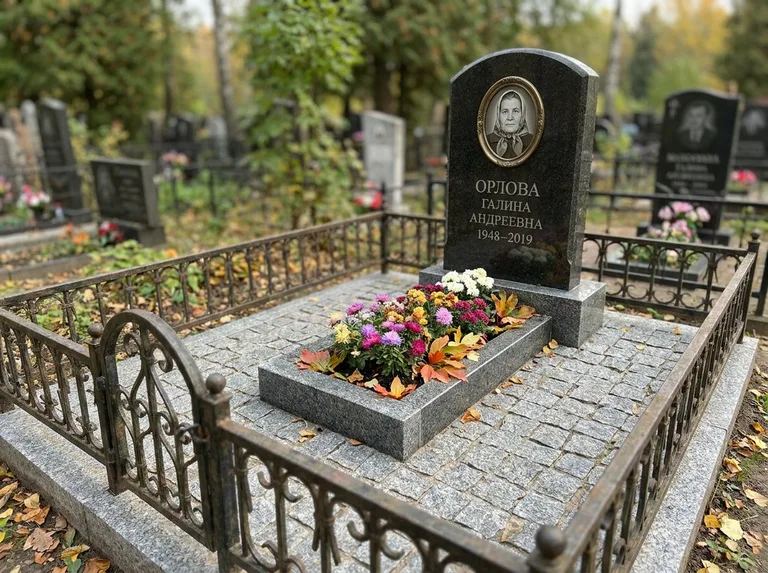 Благоустроенное захоронение с гранитной плиткой, оградой и цветником в Новосибирске