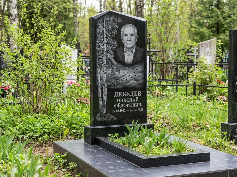 Памятник с гравировкой берёзы: вертикальная стела со скошенным верхом — берёза и стая птиц в небе, гранитный цоколь с тёмной плиткой, работа «Лебедев» в Новосибирске