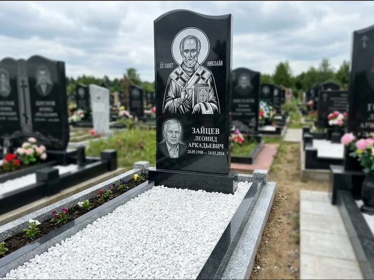 Памятник с гравировкой иконы: стела с крестообразным навершием — икона в резной рамке-киоте, газон без ограды, стриженая трава, работа «Раевская» в Новосибирске