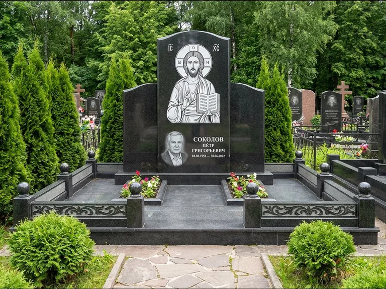 Памятник с гравировкой иконы: широкая горизонтальная лежачая плита-стела — икона в резной рамке-киоте, серая гравийная отсыпка с бордюром, работа «Богданова» в Новосибирске