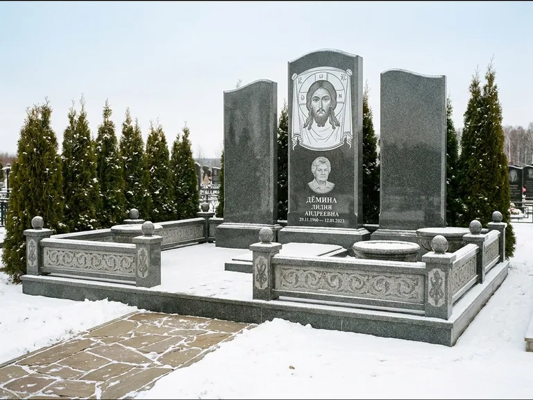 Памятник с гравировкой иконы: узкая вертикальная стела-пилон с ликом — икона в резной рамке-киоте, открытая лужайка без ограды, работа «Одинцов» в Новосибирске