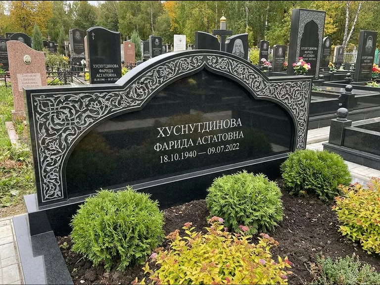 Мусульманский памятник: вытянутая горизонтальная семейная стела с аркой — белая гравировка силуэта мечети с минаретами, участок с декоративными кустами, работа «Зарипова» в Новосибирске