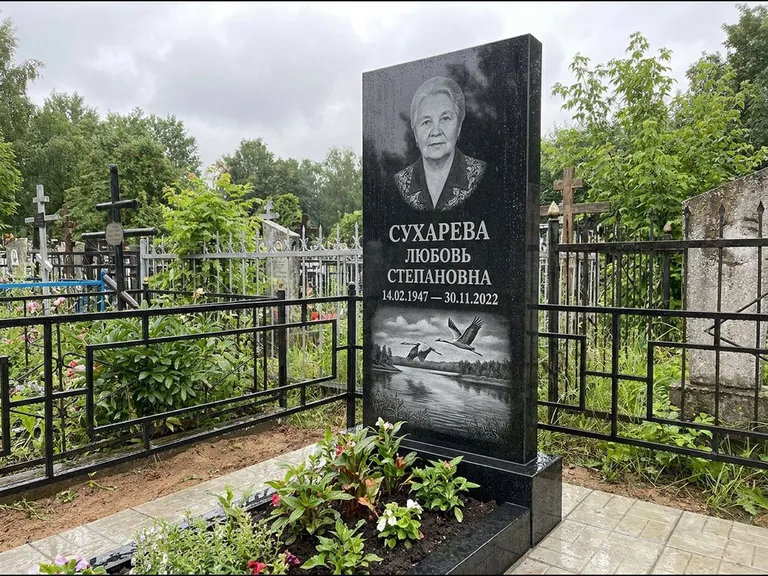 Памятник с гравировкой журавлей — гравировка пары журавлей над гладью озера в нижней части, работа «Сухарева» в Новосибирске