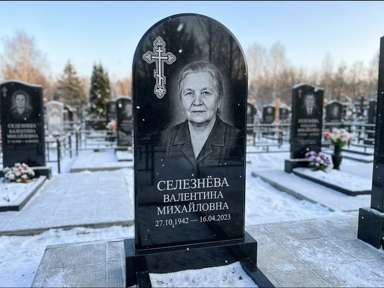 Памятник из чёрного гранита — массивная стела с крестом в лучах с крестом в лучах, работа «Одинцова» в Новосибирске