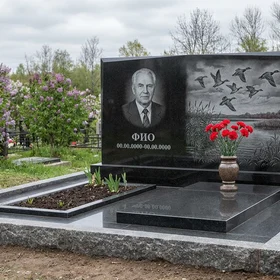Гранитный памятник охотнику в виде глыбы с гравировкой дичи